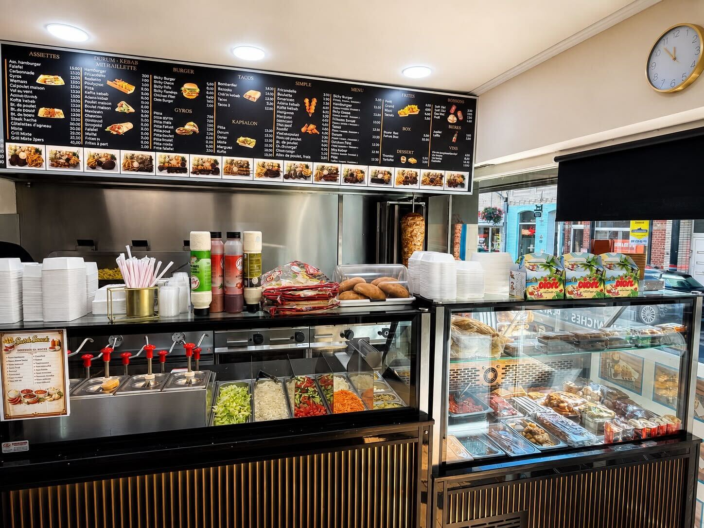 Façade illuminée de Snick Snack la nuit, enseigne néon bleue