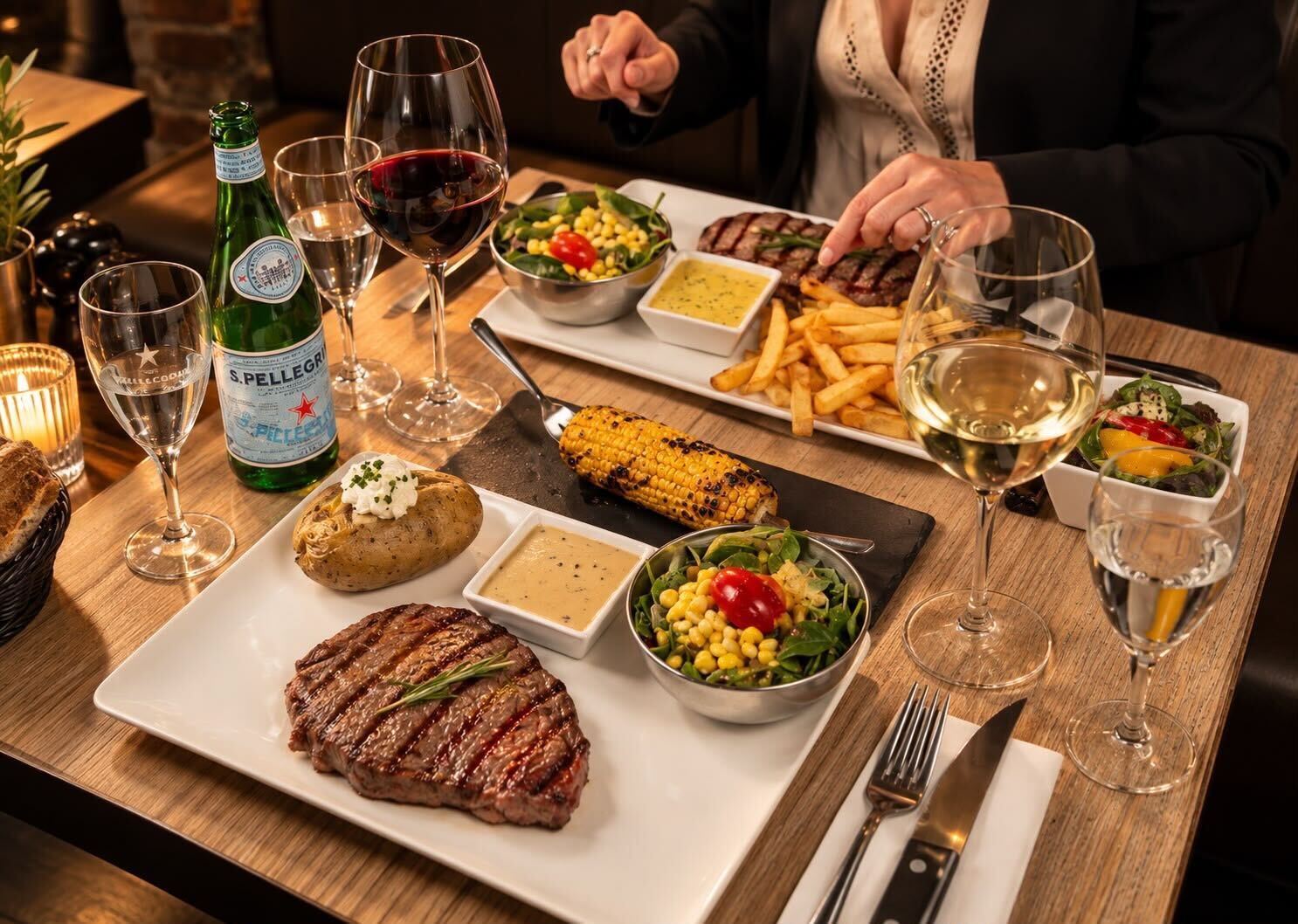 Table dressée avec viandes grillées, frites et vins chez Meat Mozart à Uccle